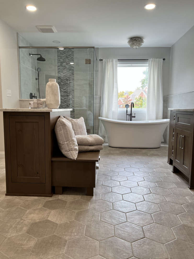 Large transitional master freestanding bathtub photo in Cincinnati with medium tone wood cabinets, quartz countertops and white countertops