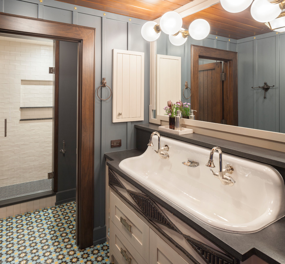 Photo of an expansive country 3/4 bathroom in Grand Rapids with white cabinets, white tile, blue walls, a trough sink, multi-coloured floor, a hinged shower door, black benchtops and shaker cabinets.