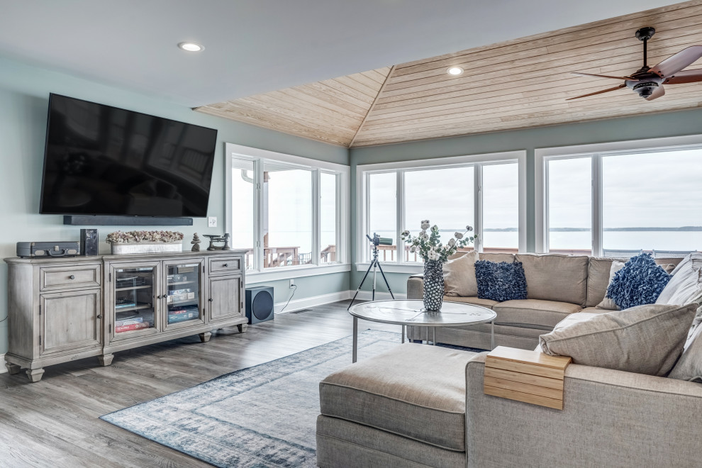 Beach style open concept living room in Richmond with blue walls, dark hardwood floors, a wall-mounted tv and brown floor.