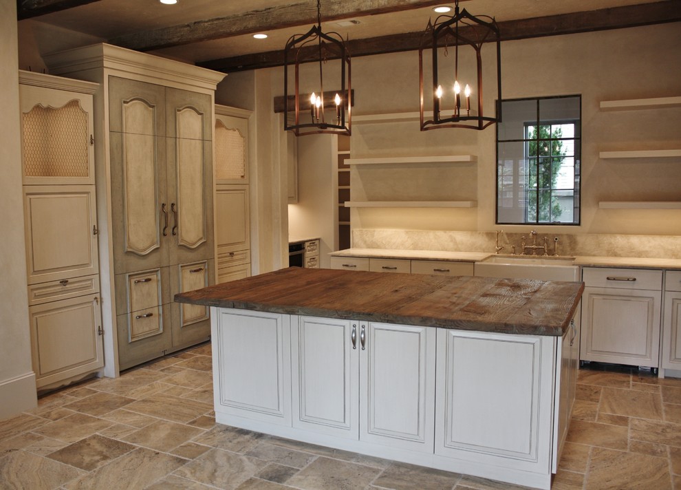 Large country u-shaped eat-in kitchen in Houston with a farmhouse sink, white cabinets, wood benchtops, beige splashback, stone slab splashback, panelled appliances, marble floors and with island.