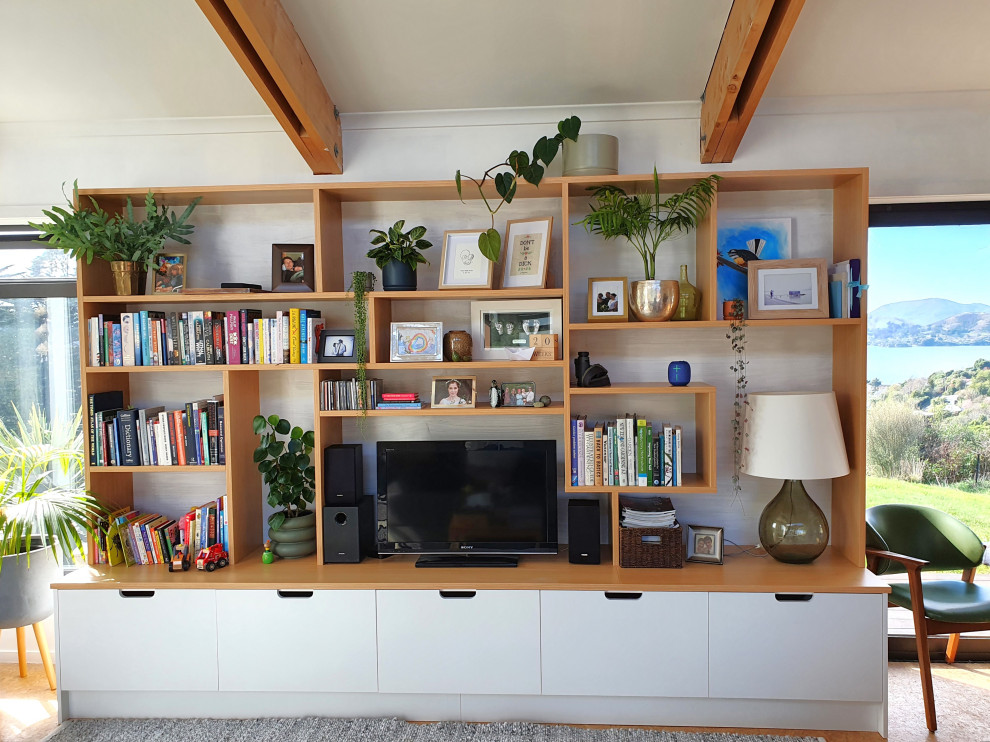 This is an example of a Mid-sized Open Concept living room in Dunedin With White Walls, a Freestanding TV and Brown Floor.