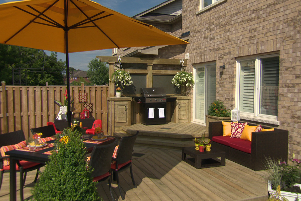 This is an example of a small traditional backyard deck in Toronto with an outdoor kitchen and no cover.