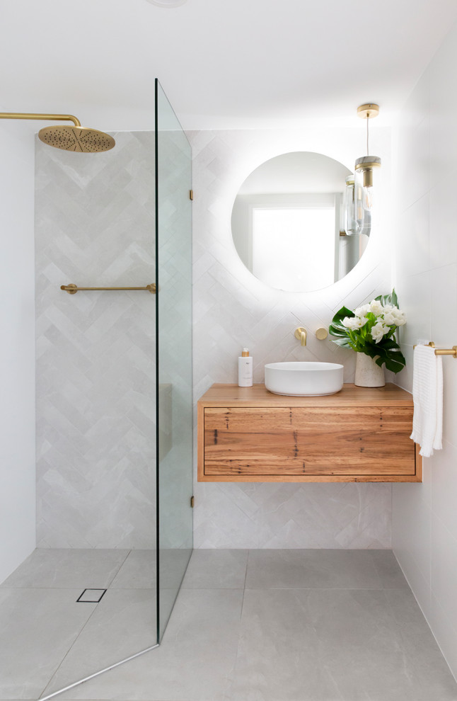This is an example of a mid-sized contemporary 3/4 bathroom in Brisbane with flat-panel cabinets, medium wood cabinets, a corner shower, gray tile, porcelain tile, porcelain floors, a vessel sink, wood benchtops, grey floor, an open shower, beige benchtops, a single vanity and a floating vanity.