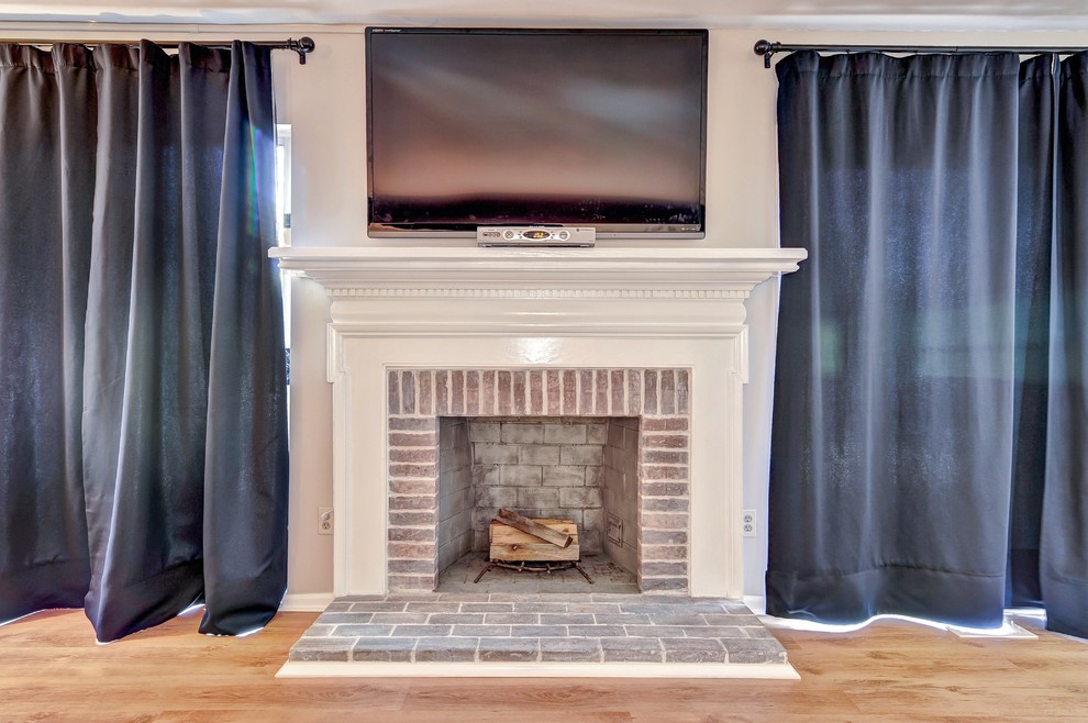Photo of a mid-sized transitional open concept family room in Philadelphia with beige walls, a standard fireplace, a brick fireplace surround and a wall-mounted tv.