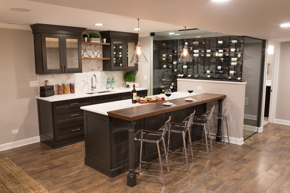 This is an example of a mid-sized transitional galley wet bar in Chicago with an undermount sink, glass-front cabinets, black cabinets, quartz benchtops, multi-coloured splashback, ceramic splashback, medium hardwood floors, brown floor and multi-coloured benchtop.