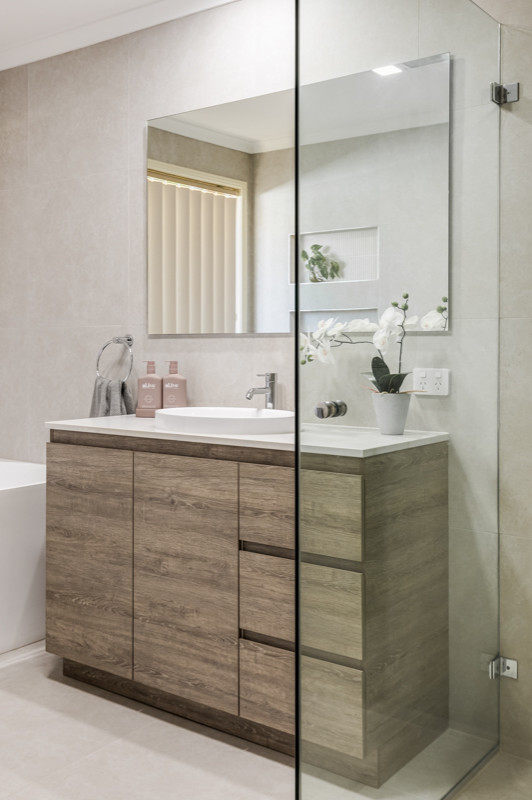 Mid-sized contemporary master bathroom in Sydney with flat-panel cabinets, light wood cabinets, an alcove shower, a two-piece toilet, gray tile, a vessel sink, grey floor, a hinged shower door, white benchtops, a niche, a double vanity and a freestanding vanity.