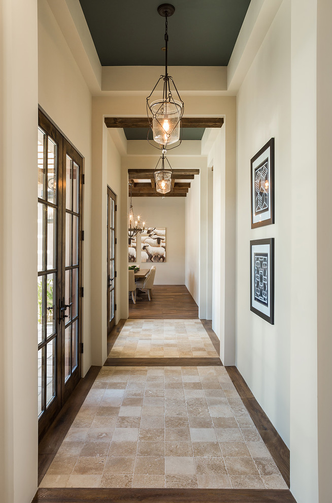 Inspiration for an expansive mediterranean hallway in Phoenix with beige walls, limestone floors and beige floor.