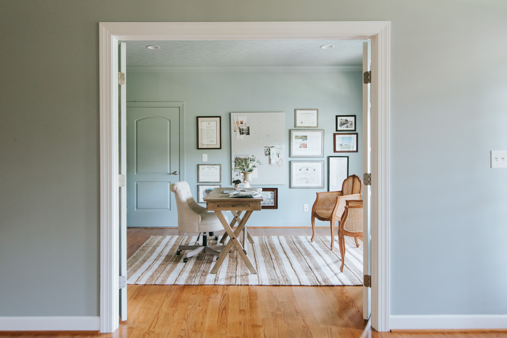 Inspiration för stora klassiska arbetsrum, med blå väggar, mellanmörkt trägolv och ett fristående skrivbord