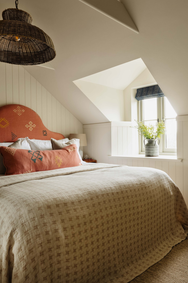 Photo of a small bohemian master bedroom in Cornwall with beige walls, carpet, beige floors, a vaulted ceiling, tongue and groove walls and feature lighting.