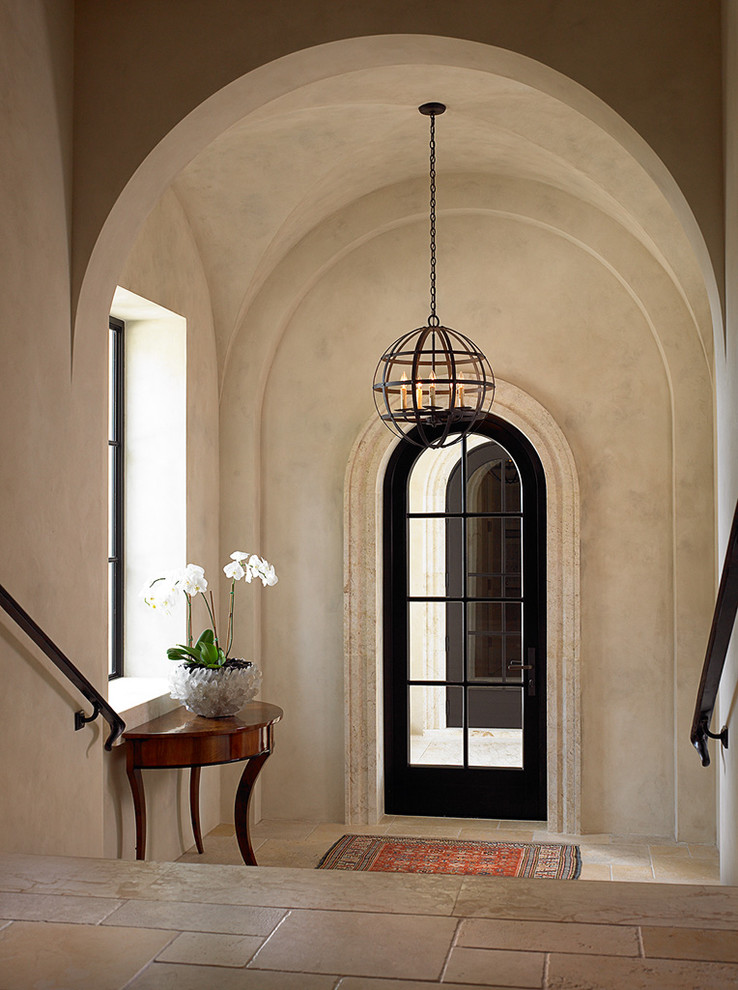 Inspiration for a mid-sized mediterranean foyer in Miami with beige walls, a single front door and a glass front door.
