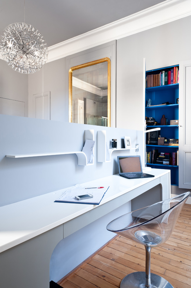 This is an example of a contemporary study room in Bordeaux with grey walls, medium hardwood floors and a built-in desk.