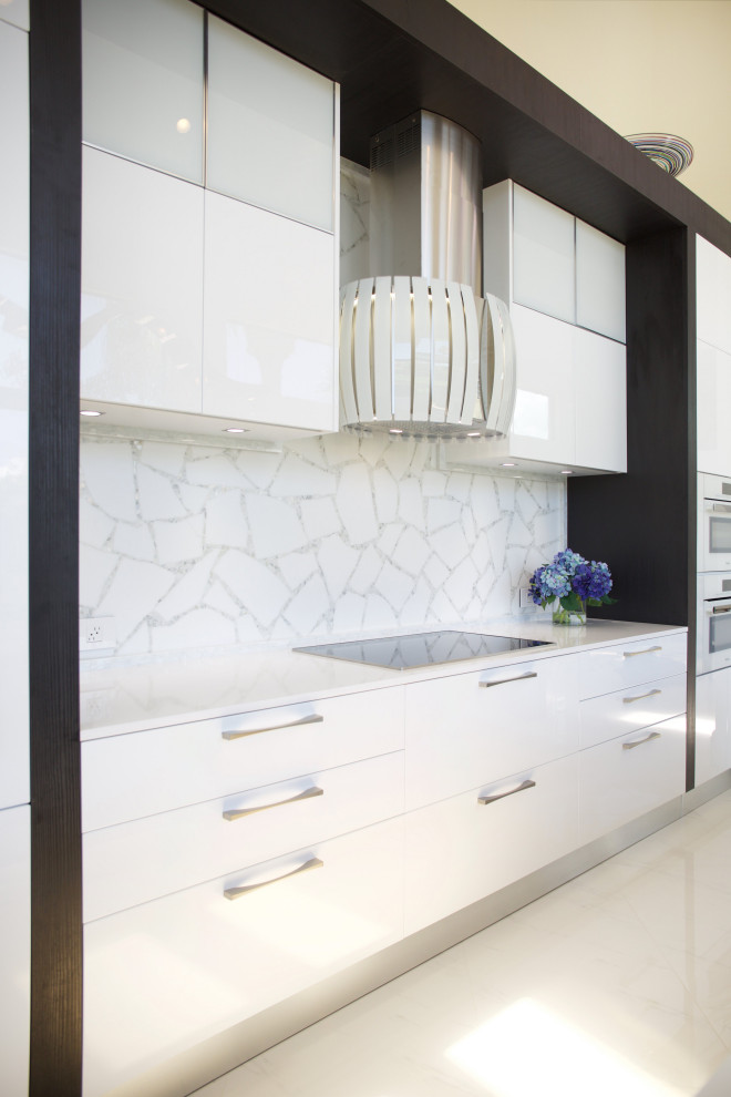 This is an example of an expansive contemporary single-wall eat-in kitchen in Miami with flat-panel cabinets, white cabinets, quartzite benchtops, white splashback, glass tile splashback, white appliances, porcelain floors, with island, white floor, white benchtop and vaulted.
