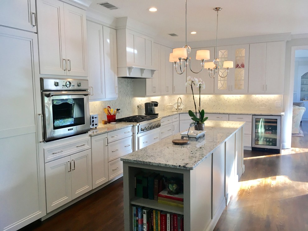 Inspiration for a large transitional u-shaped dark wood floor and brown floor eat-in kitchen remodel with a farmhouse sink, recessed-panel cabinets, beige cabinets, granite countertops, white backsplash, marble backsplash, stainless steel appliances and an island