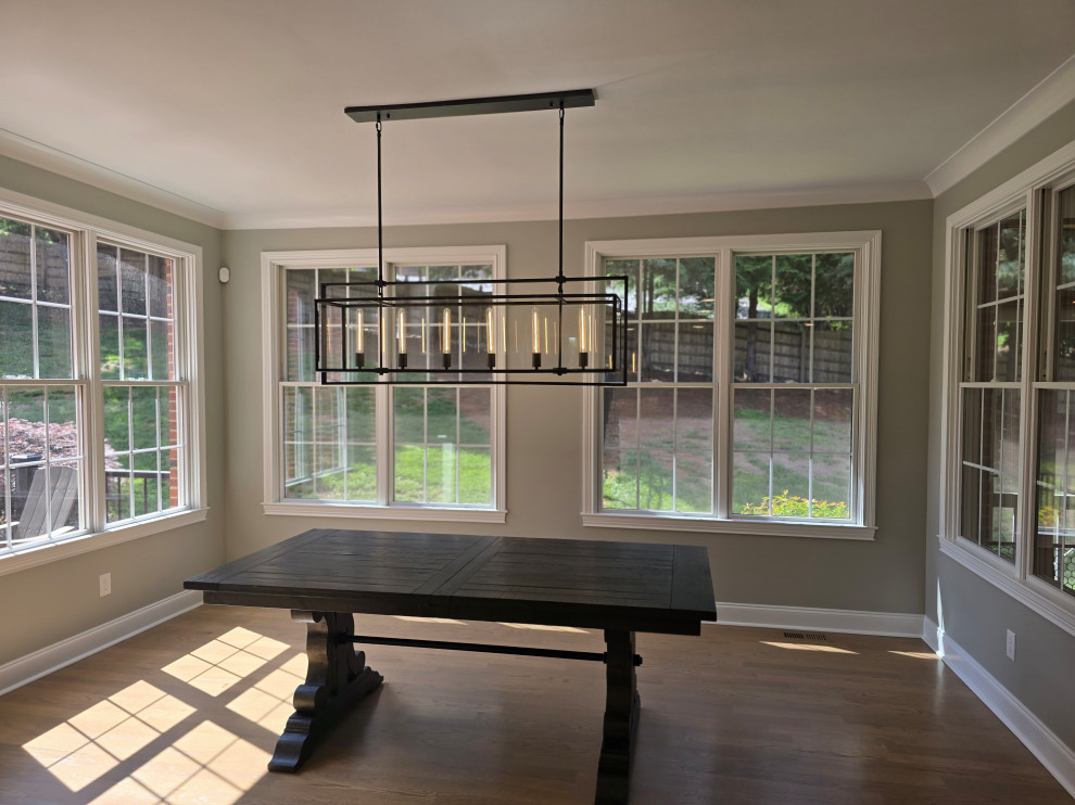 Large minimalist medium tone wood floor and brown floor enclosed dining room photo with gray walls