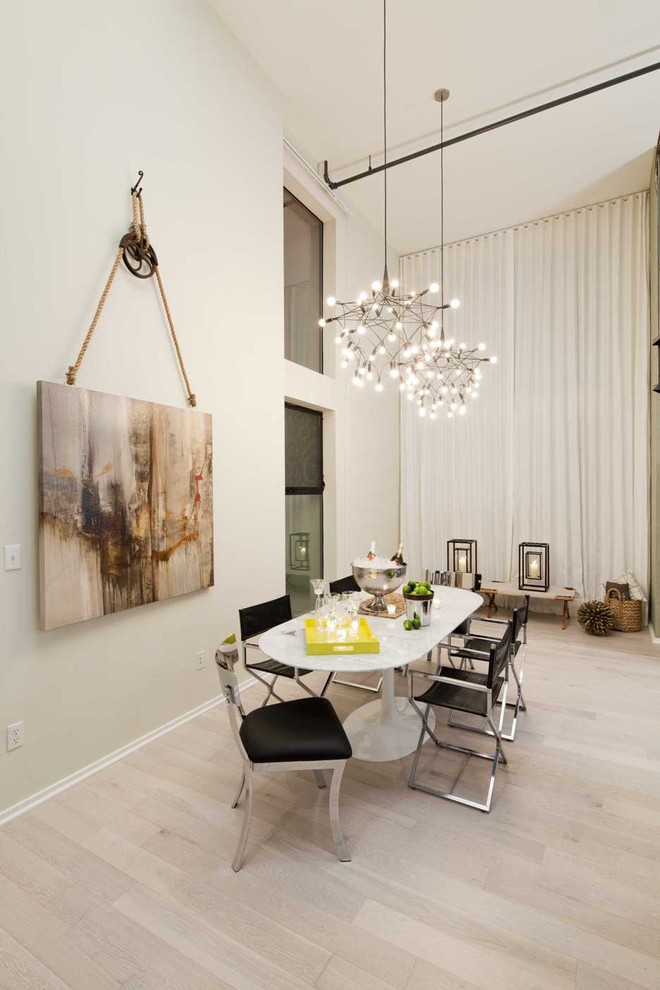 Photo of a contemporary dining room in Los Angeles with light hardwood floors and beige walls.