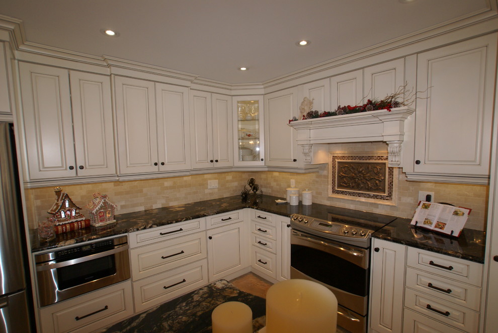 Example of a mid-sized transitional eat-in kitchen design with recessed-panel cabinets, beige cabinets, granite countertops, multicolored backsplash and stainless steel appliances
