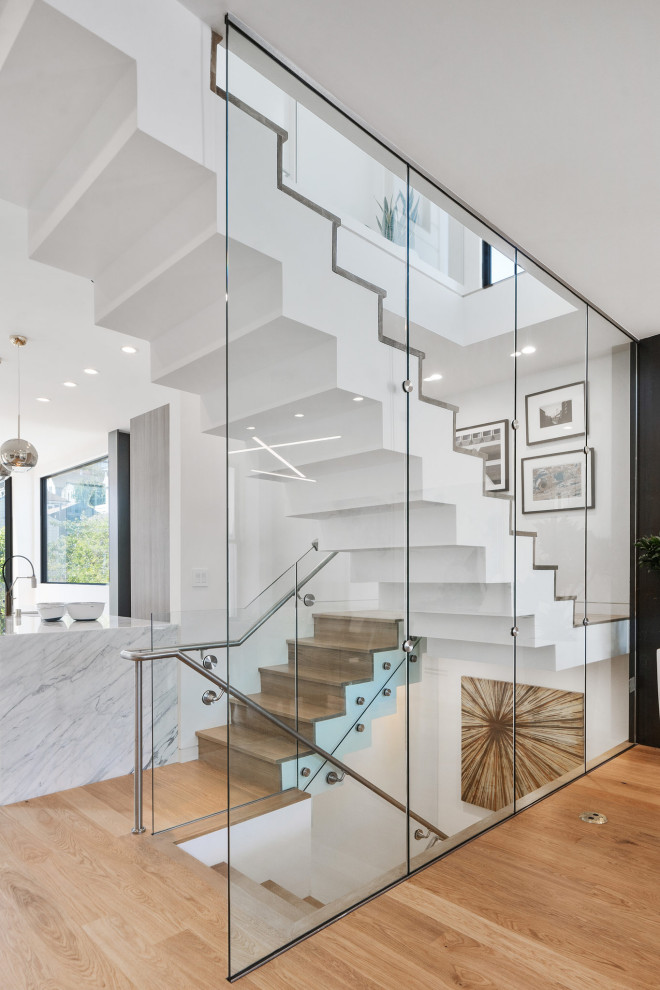 Inspiration for a mid-sized contemporary wood u-shaped staircase in San Francisco with wood risers and glass railing.