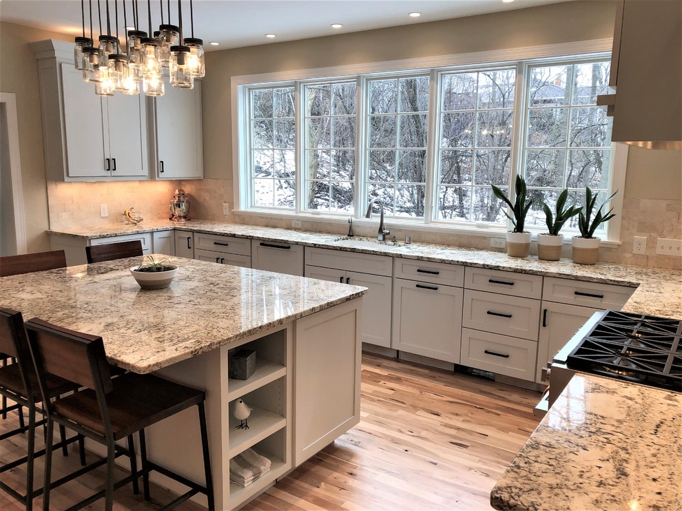 This is an example of a large transitional separate kitchen in Other with an undermount sink, shaker cabinets, white cabinets, granite benchtops, stone tile splashback, medium hardwood floors and with island.