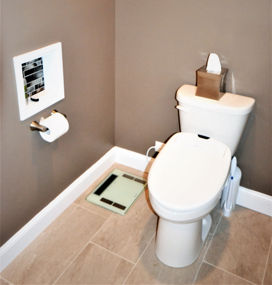 This is an example of a large transitional powder room in Philadelphia with raised-panel cabinets, brown cabinets, a bidet, beige tile, ceramic tile, beige walls, ceramic floors, an undermount sink, granite benchtops, beige floor, multi-coloured benchtops and a built-in vanity.