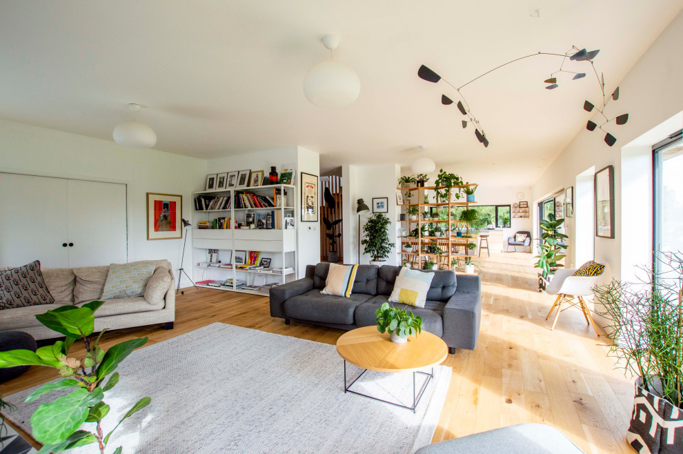Scandinavian open concept living room in Other with white walls, light hardwood floors and beige floor.