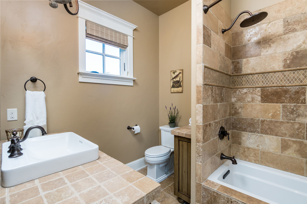 This is an example of a large mediterranean master bathroom in Other with raised-panel cabinets, beige cabinets, brown tile, limestone, beige walls, limestone floors, a drop-in sink and brown floor.