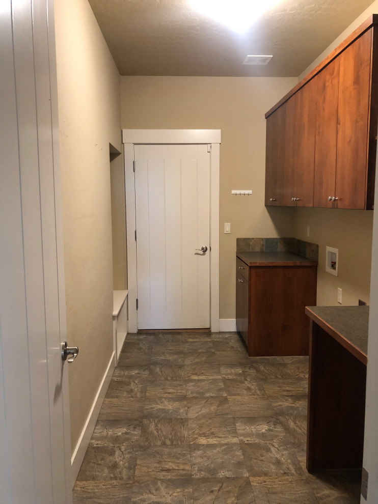 Inspiration for a small transitional galley utility room in Boise with flat-panel cabinets, brown cabinets, laminate benchtops, brown splashback, ceramic splashback, beige walls, linoleum floors and a side-by-side washer and dryer.