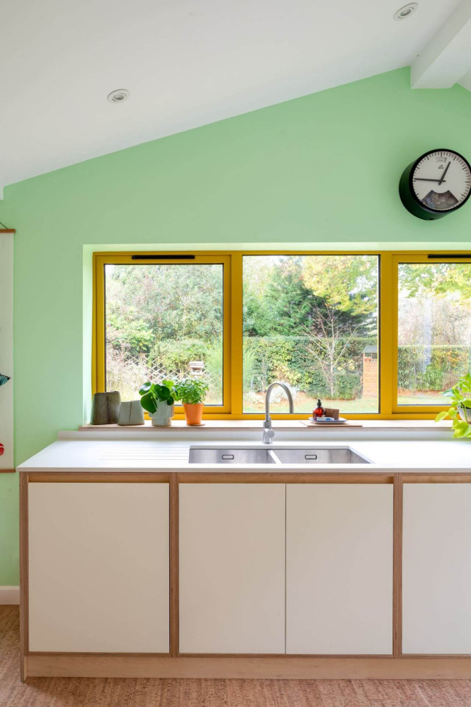 Immagine di una cucina minimalista di medie dimensioni con lavello a doppia vasca, ante lisce e pavimento in sughero