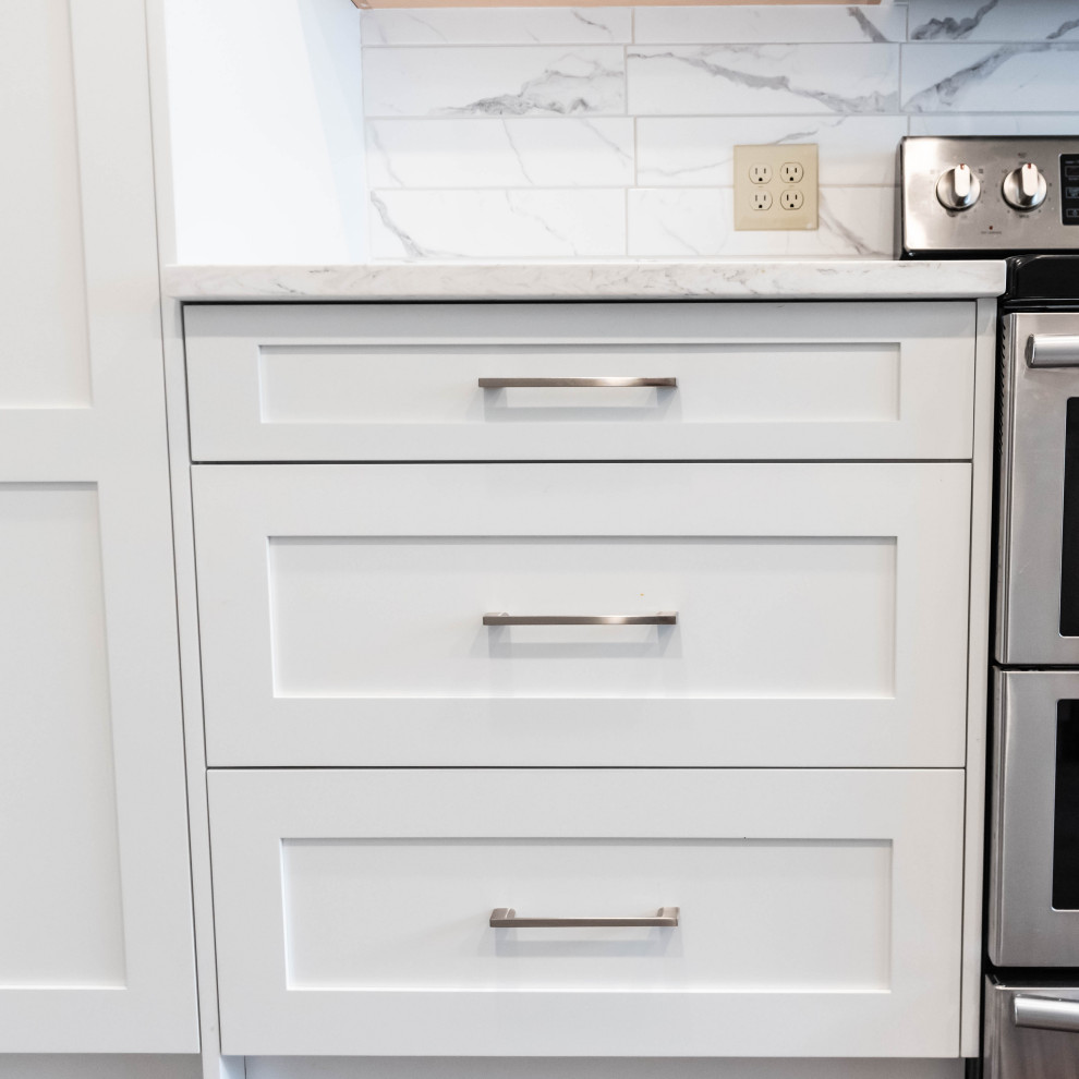 Exempel på ett mellanstort modernt vit linjärt vitt kök och matrum, med skåp i shakerstil, vita skåp, bänkskiva i kvartsit, grått stänkskydd, stänkskydd i keramik, rostfria vitvaror och en köksö