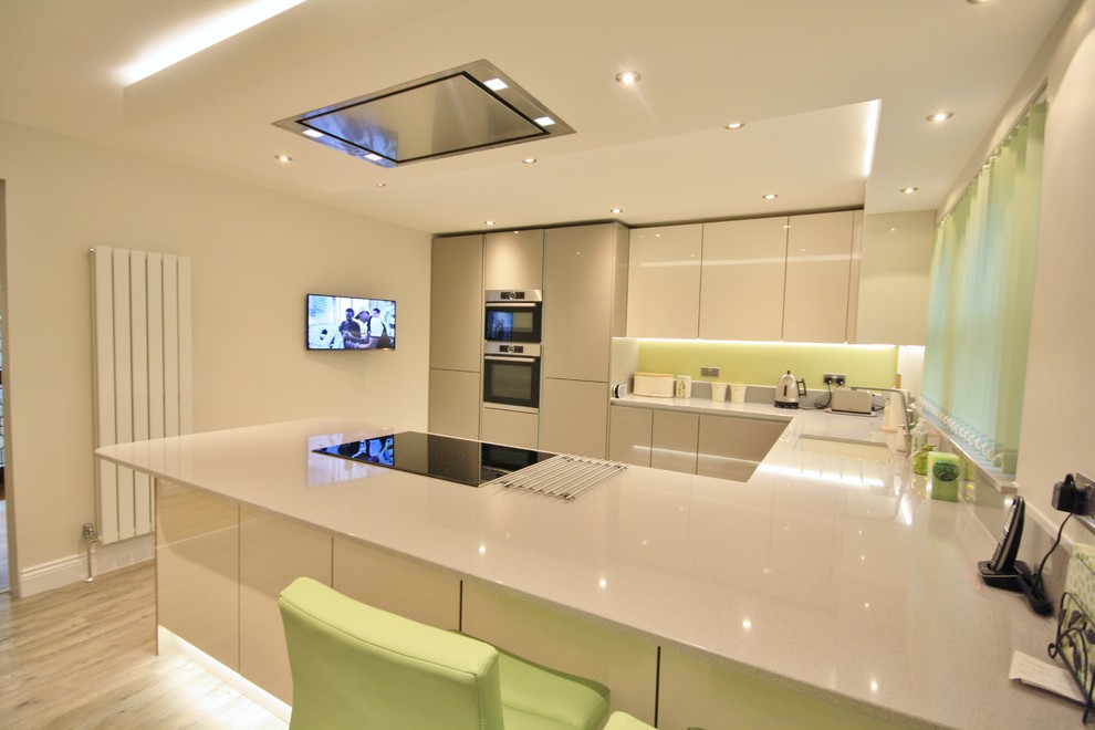 Photo of a large contemporary u-shaped eat-in kitchen in Essex with a single-bowl sink, flat-panel cabinets, grey cabinets, quartzite benchtops, stainless steel appliances and no island.