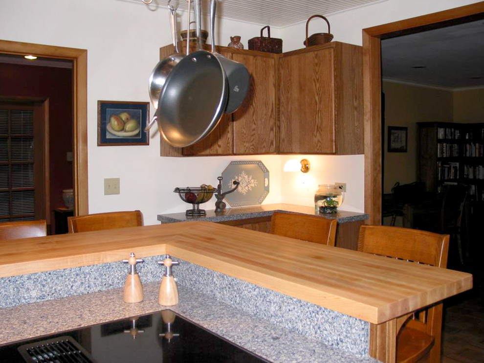 This is an example of a mid-sized arts and crafts l-shaped open plan kitchen in Seattle with a double-bowl sink, flat-panel cabinets, medium wood cabinets, quartz benchtops, blue splashback, medium hardwood floors, with island, blue benchtop, white appliances, brown floor, timber and engineered quartz splashback.