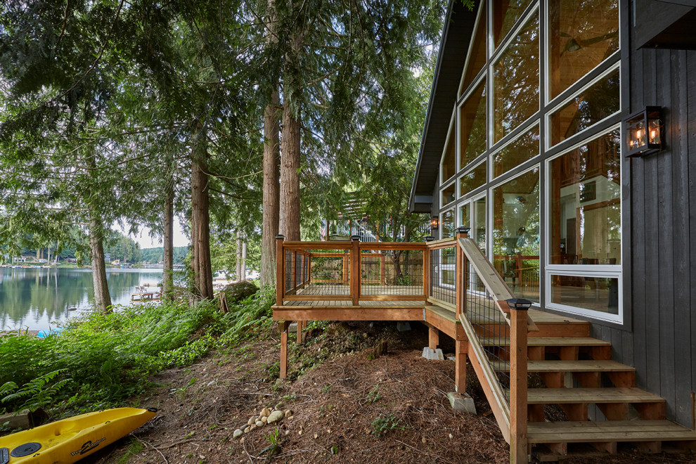 Стильный дизайн: маленький, двухэтажный, деревянный, черный мини дом в стиле рустика с двускатной крышей, металлической крышей и серой крышей для на участке и в саду - последний тренд