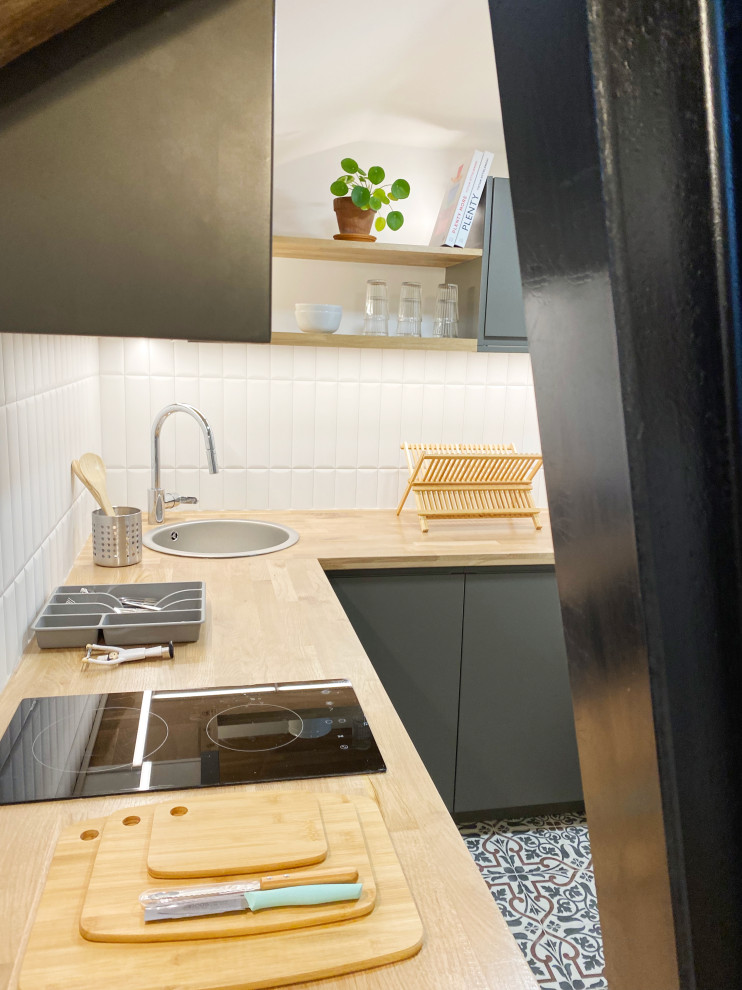 Réalisation d'une petite cuisine design avec un plan de travail en bois et une crédence blanche.