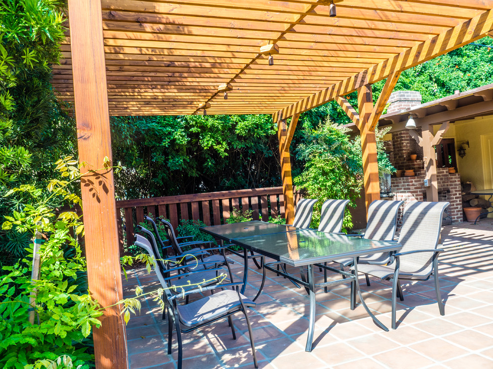 Imagen de jardín de secano mediterráneo de tamaño medio en primavera en patio trasero con brasero, exposición total al sol, adoquines de ladrillo y con madera