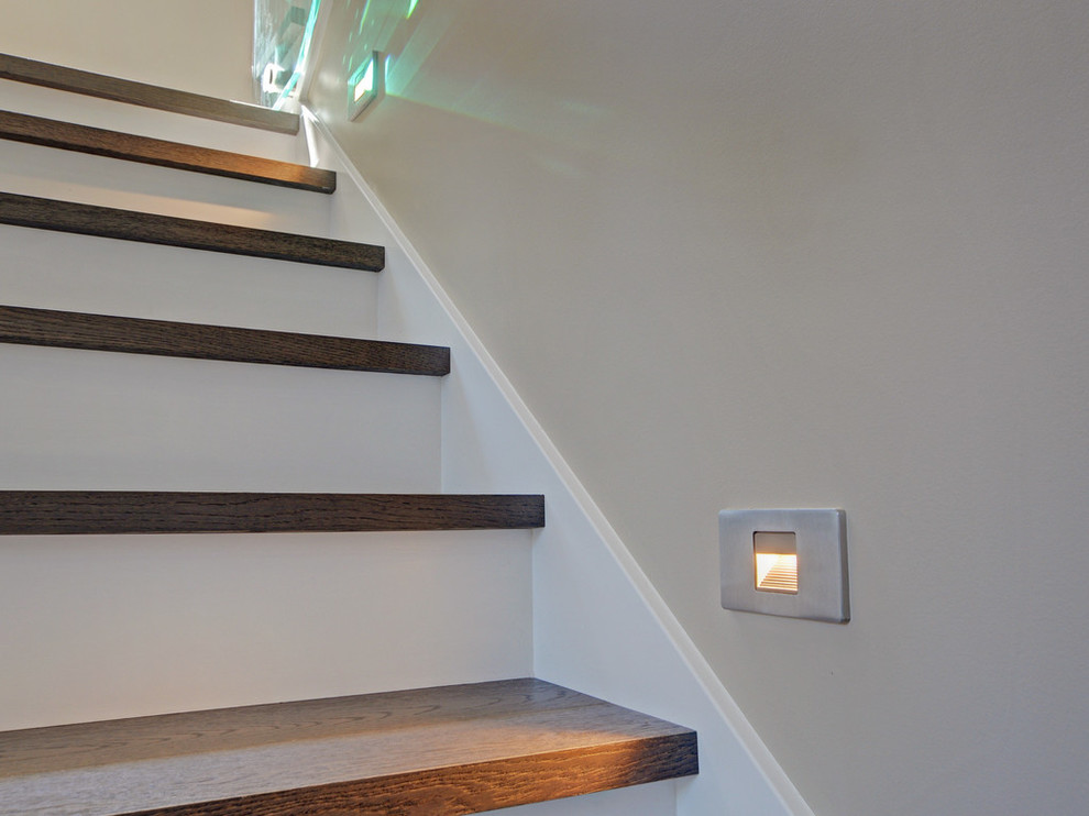 This is an example of a mid-sized contemporary wood u-shaped staircase in Vancouver with painted wood risers.