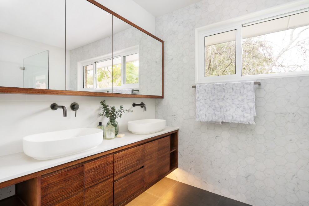 Design ideas for a contemporary bathroom in Sydney with flat-panel cabinets, dark wood cabinets, white tile, a vessel sink, grey floor and white benchtops.