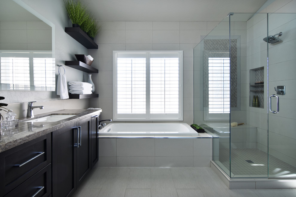 Example of a mid-sized transitional master white tile drop-in bathtub design in Phoenix with shaker cabinets, dark wood cabinets, a one-piece toilet, an undermount sink, a hinged shower door and blue walls