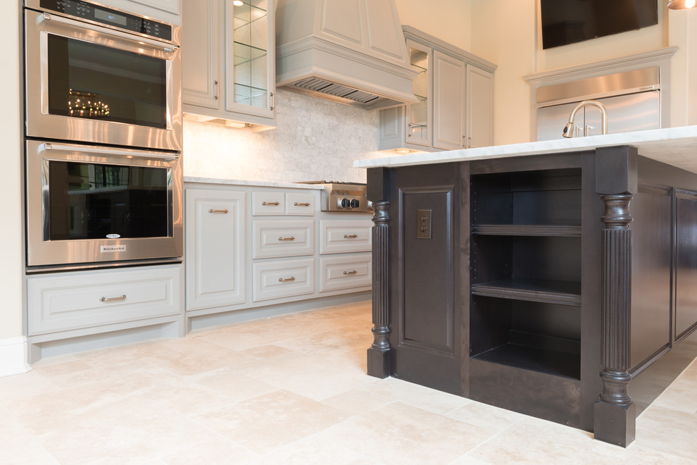 Open concept kitchen - huge transitional l-shaped porcelain tile and beige floor open concept kitchen idea in Houston with a farmhouse sink, raised-panel cabinets, gray cabinets, marble countertops, gray backsplash, subway tile backsplash, stainless steel appliances, an island and white countertops
