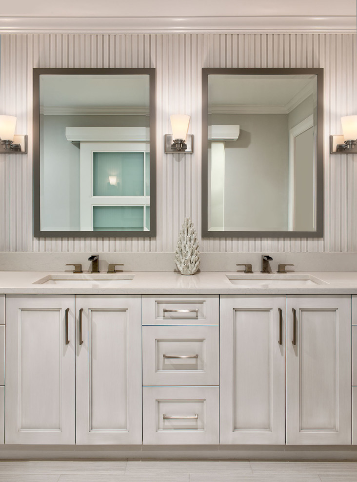 Design ideas for a large beach style master bathroom in Miami with recessed-panel cabinets, grey cabinets, a freestanding tub, a two-piece toilet, an undermount sink, a curbless shower, porcelain tile, white walls, porcelain floors, quartzite benchtops and white benchtops.