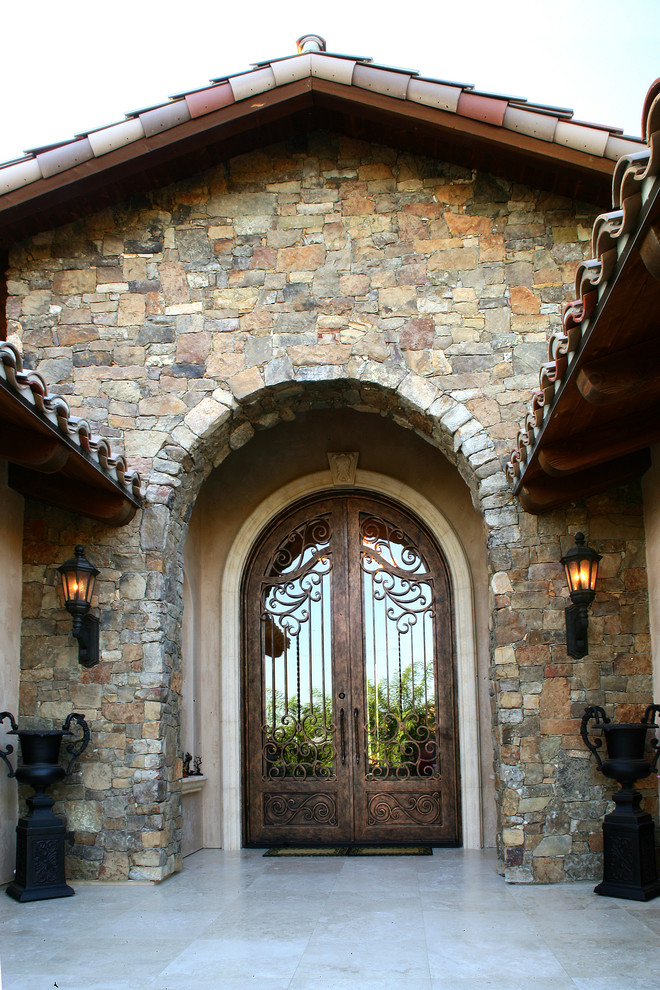 This is an example of an expansive mediterranean front door in San Diego with multi-coloured walls, a double front door and a brown front door.