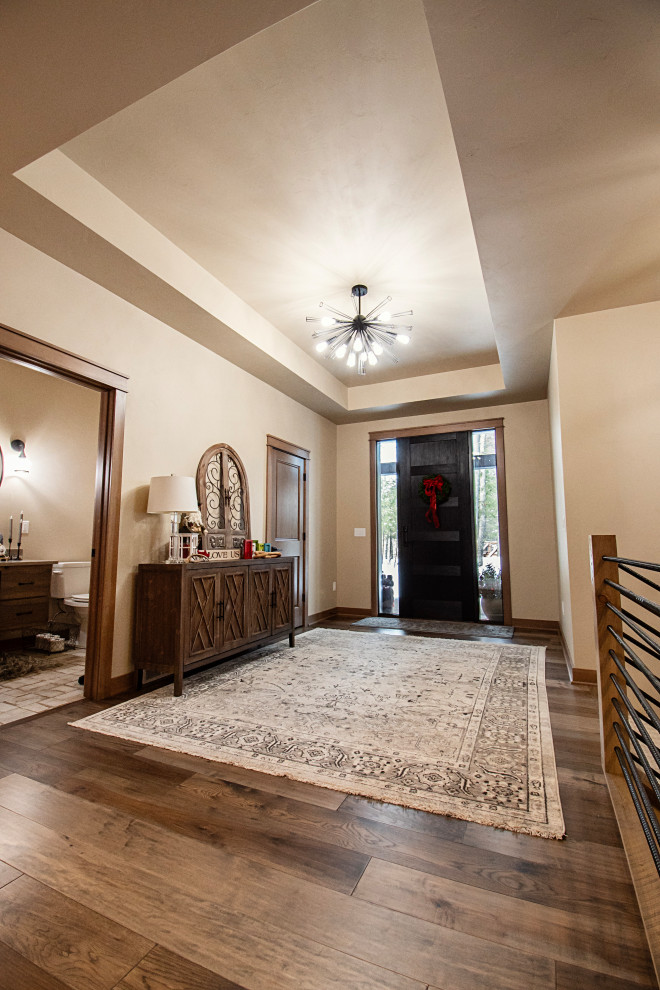 Example of a mid-sized mountain style medium tone wood floor and multicolored floor front door design with a black front door