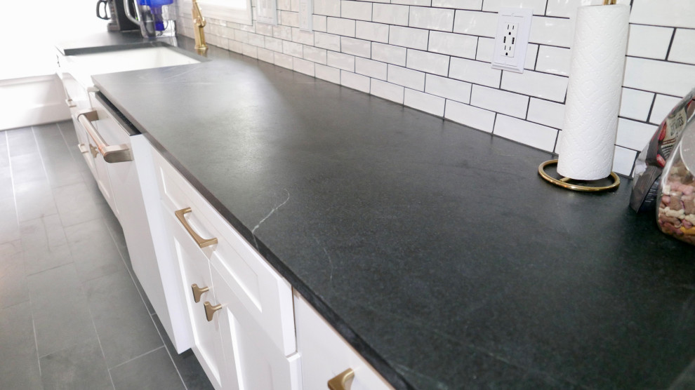 Inspiration for a mid-sized transitional galley porcelain tile and black floor eat-in kitchen remodel with a farmhouse sink, shaker cabinets, blue cabinets, marble countertops, white backsplash, subway tile backsplash, white appliances, an island and multicolored countertops