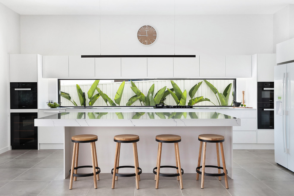 This is an example of a contemporary l-shaped kitchen in Sydney with quartz benchtops, window splashback, black appliances, ceramic floors, with island, grey floor, white benchtop, flat-panel cabinets and white cabinets.