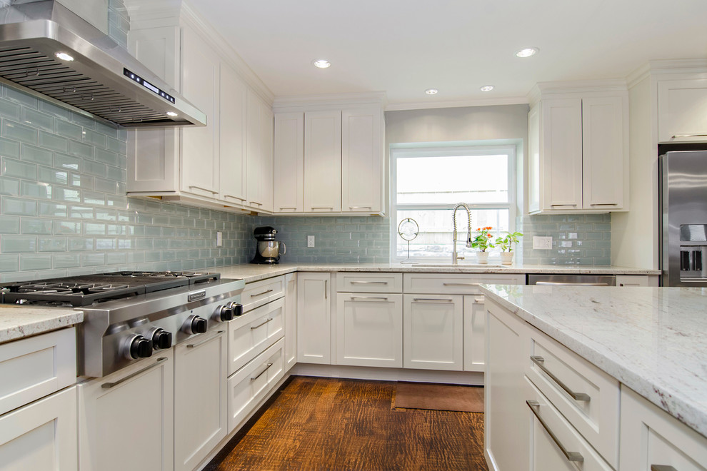 Photo of a transitional l-shaped eat-in kitchen in Dallas with an undermount sink, shaker cabinets, white cabinets, granite benchtops, blue splashback, glass tile splashback and stainless steel appliances.