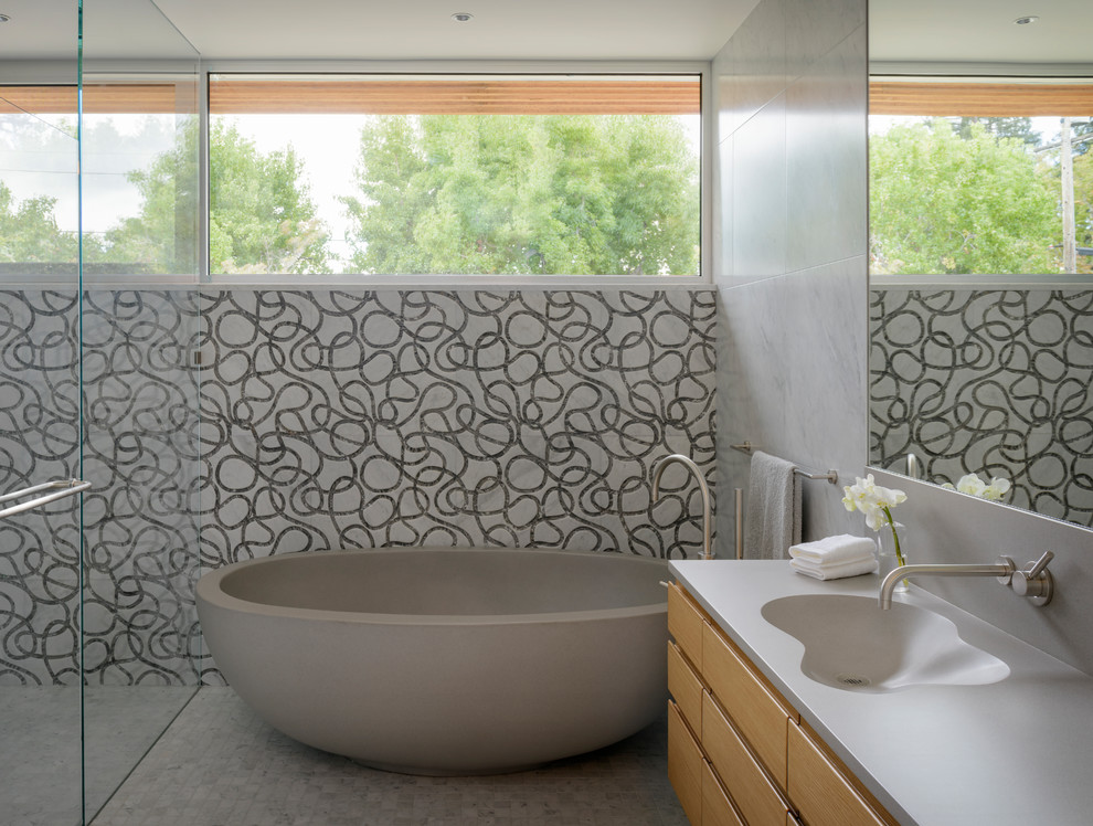 Inspiration for a contemporary master bathroom in San Francisco with shaker cabinets, medium wood cabinets, a freestanding tub, a curbless shower, gray tile, mosaic tile, grey walls, medium hardwood floors, an undermount sink, concrete benchtops, brown floor, a hinged shower door and grey benchtops.