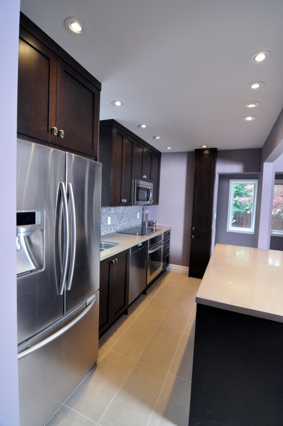 Design ideas for a large contemporary l-shaped eat-in kitchen in Toronto with a double-bowl sink, recessed-panel cabinets, dark wood cabinets, quartz benchtops, blue splashback, mosaic tile splashback, stainless steel appliances, ceramic floors and with island.