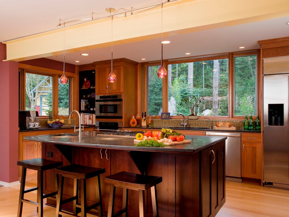 Mid-sized transitional l-shaped light wood floor and beige floor eat-in kitchen photo in Seattle with an undermount sink, shaker cabinets, medium tone wood cabinets, granite countertops, multicolored backsplash, glass tile backsplash, stainless steel appliances and an island