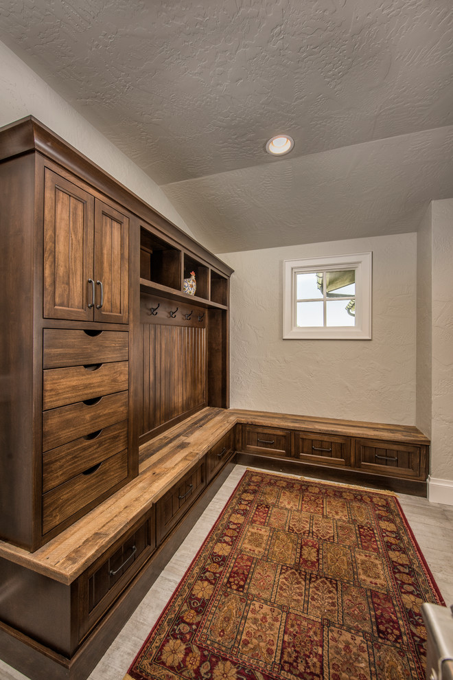 Mid-sized mountain style l-shaped mudroom photo with raised-panel cabinets, medium tone wood cabinets and an island