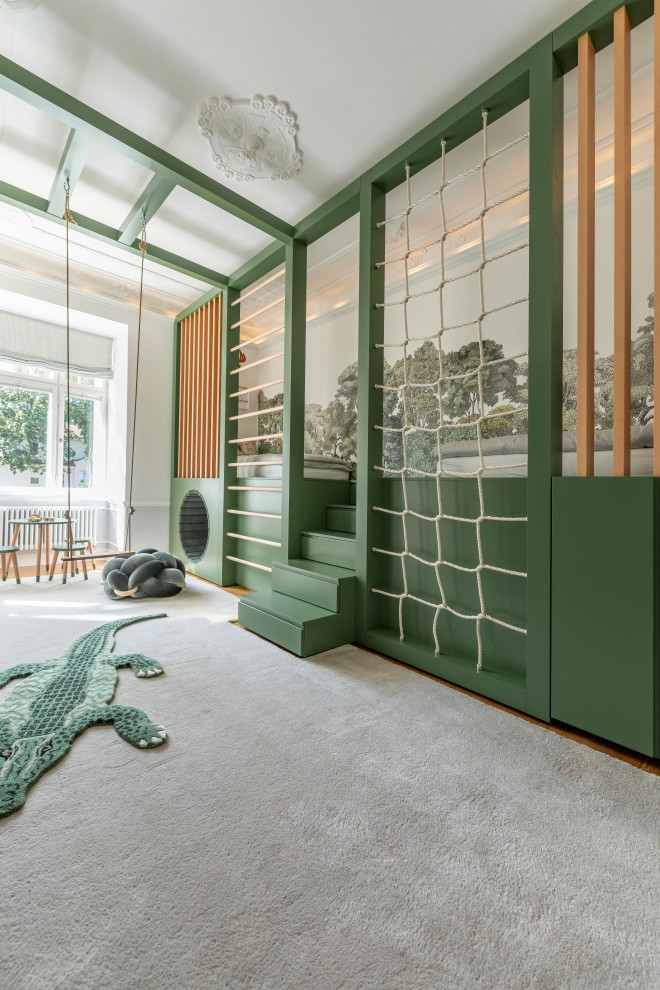 This is an example of a mid-sized transitional kids' playroom for kids 4-10 years old and boys in Dresden with green walls, carpet, grey floor and wallpaper.