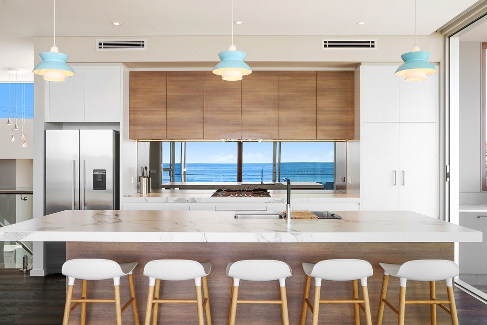 Contemporary galley kitchen in Central Coast with an undermount sink, flat-panel cabinets, white cabinets, window splashback, dark hardwood floors, with island and brown floor.