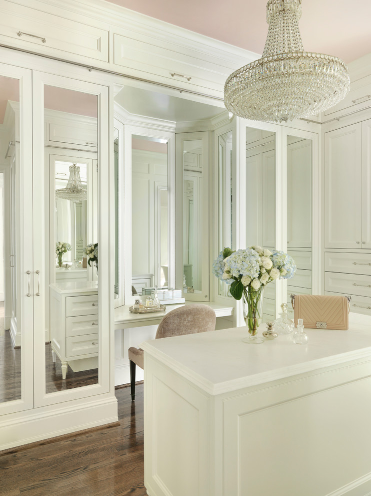 Inspiration for a large traditional women's dressing room in St Louis with recessed-panel cabinets, white cabinets, brown floor and dark hardwood floors.